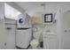 Small bathroom includes toilet, sink, shower, and stacked washer/dryer at 130 Virginia Ct, Englewood, FL 34223