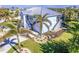 Elevated view of a two-story light blue house with a metal roof and surrounding landscaping at 13104 Via Cassia, Placida, FL 33946