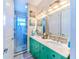 Bathroom with teal double vanity, glass shower, and flamingo artwork at 13104 Via Cassia, Placida, FL 33946