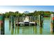 A community dock has wooden columns along the dock with a sign reading 'Placida Beach' surrounded by trees at 13104 Via Cassia, Placida, FL 33946