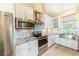 White kitchen with stainless steel appliances and granite countertops at 13104 Via Cassia, Placida, FL 33946