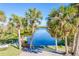 Calm canal-front view with lush vegetation, a dock, and a swing set at 13104 Via Cassia, Placida, FL 33946