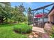 Landscaped backyard with spacious lawn and screened patio at 13123 Preserve Ct, Port Charlotte, FL 33953