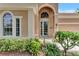 Light teal front door with arched entryway and landscape at 13123 Preserve Ct, Port Charlotte, FL 33953