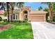 Tan one-story house with tile roof, two-car garage, and lush landscaping at 13123 Preserve Ct, Port Charlotte, FL 33953