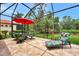 Relaxing screened lanai with seating and red umbrella at 13123 Preserve Ct, Port Charlotte, FL 33953