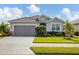 Charming single-story home with a gray exterior, landscaped yard, and paved driveway at 15137 Spanish Point Dr, Port Charlotte, FL 33981