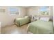 Two twin beds, nightstand, and window with blinds in a cozy bedroom at 1531 Placida Rd # 1-204, Englewood, FL 34223
