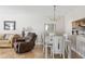 Dining area with a white table, chandelier, and view of the kitchen at 1531 Placida Rd # 1-204, Englewood, FL 34223