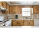 Bright kitchen features wood cabinets, white appliances, and a double sink at 1531 Placida Rd # 1-204, Englewood, FL 34223