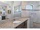 Bathroom with granite vanity, walk-in shower, and tiled walls at 15336 Lakeland Cir, Port Charlotte, FL 33981