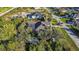Aerial view of a house with a pool and lush landscaping in a residential neighborhood at 15375 Taurus Cir, Port Charlotte, FL 33981