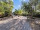 Large, tropical backyard with gravel pathway and palm trees at 15375 Taurus Cir, Port Charlotte, FL 33981