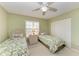 Bedroom features two twin beds, green walls, a ceiling fan, and a closet at 15375 Taurus Cir, Port Charlotte, FL 33981