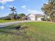 Three-car garage home with lush landscaping, and a long driveway at 15375 Taurus Cir, Port Charlotte, FL 33981