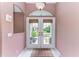 Inviting foyer featuring double doors, neutral tile flooring, fresh paint and a decorative area rug at 15375 Taurus Cir, Port Charlotte, FL 33981