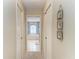 Hallway view of a bathroom featuring tile flooring, a tub, and a decorative arched window at 15375 Taurus Cir, Port Charlotte, FL 33981