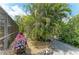 Beautifully landscaped yard featuring a lush palm tree, decorative flowers, and a charming stone pathway at 15375 Taurus Cir, Port Charlotte, FL 33981