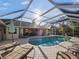 Inviting pool area with covered patio, lounge chairs, and a fountain at 15375 Taurus Cir, Port Charlotte, FL 33981