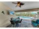 Inviting screened-in pool patio with dining area, fan, TV, and comfortable seating for relaxing outdoors at 15375 Taurus Cir, Port Charlotte, FL 33981