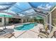 Stunning view of the screened-in pool and patio area, complete with lounge chairs and outdoor dining space at 15375 Taurus Cir, Port Charlotte, FL 33981