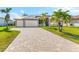 House exterior featuring a paver driveway and manicured lawn at 15476 Alsask Cir, Port Charlotte, FL 33981