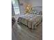 Cozy bedroom with natural light, neutral colors, and stylish gray wood-look floors at 15500 Longview Rd, Port Charlotte, FL 33981