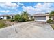 Front view of a single story house with a large driveway and landscaping at 15500 Longview Rd, Port Charlotte, FL 33981