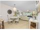 Bright dining room with white table and chairs, overlooking living room at 1651 Beach Rd # 212, Englewood, FL 34223