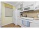 White kitchen with ample counter space, built-in microwave and refrigerator at 1651 Beach Rd # 212, Englewood, FL 34223