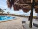 Community pool with thatch umbrella and waterfront views at 1751 Beach Rd # 204, Englewood, FL 34223