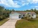 Single-story house with a garage and palm tree, front yard, and driveway at 2251 Meetze St, Port Charlotte, FL 33953