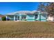 Light teal home with gray roof and landscaped yard at 2271 Paraiso Ct, Englewood, FL 34224
