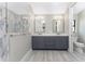 Double vanity bathroom with gray cabinets and marble shower at 35 Broadmoor Ln, Rotonda West, FL 33947