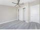 Bright bedroom with grey wood-look floors, ceiling fan, and spacious closet at 35 Broadmoor Ln, Rotonda West, FL 33947