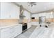 Modern kitchen featuring white cabinets, granite countertops, and stainless steel appliances at 35 Broadmoor Ln, Rotonda West, FL 33947