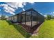 Exterior view of home with screened pool enclosure and lush green lawn at 35 Broadmoor Ln, Rotonda West, FL 33947
