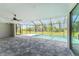 Screened lanai with pool, ceiling fan, and view of backyard through the screen at 35 Broadmoor Ln, Rotonda West, FL 33947