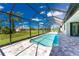 Screened pool and patio area with modern tile; view of backyard at 35 Broadmoor Ln, Rotonda West, FL 33947