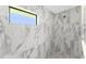 Modern shower with marble-style tile and pebble floor at 35 Broadmoor Ln, Rotonda West, FL 33947