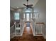 Open hallway with hardwood floors, white railings and a view of the entryway at 5177 The Pointe, Englewood, FL 34223