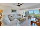 Bright living room with white slipcovered furniture and water views at 5856 Gasparilla Rd # M27, Boca Grande, FL 33921