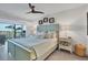 Main bedroom with water views, king-size bed, and ceiling fan at 5856 Gasparilla Rd # M27, Boca Grande, FL 33921
