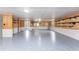 Spacious basement featuring durable epoxy flooring, ample storage shelves, and paneled walls at 6341 Biggs St, Englewood, FL 34224