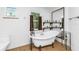 Bathroom with clawfoot tub, wood shelving, and a large mirror at 6341 Biggs St, Englewood, FL 34224