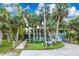 Two story home with a walkway, surrounded by lush tropical landscaping at 6341 Biggs St, Englewood, FL 34224