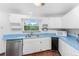 Galley kitchen with white cabinets, blue countertops, and built in microwave at 6341 Biggs St, Englewood, FL 34224