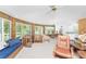 Bright and airy living room with wood paneling, large windows, and comfortable seating arrangement with carpet floors at 6341 Biggs St, Englewood, FL 34224