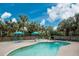 Large kidney-shaped pool with surrounding patio and umbrellas at 6341 Biggs St, Englewood, FL 34224