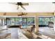 Sunroom with wicker chairs, a glass-top table, and screened windows overlooking the yard at 6375 Biggs St, Englewood, FL 34224